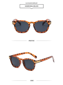 Detail view showing tortoiseshell frame texture and gold hinge accents of retro sunglasses