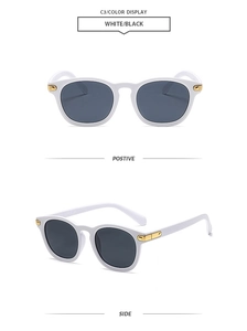 Detail view of white retro sunglasses with dark lenses and gold metal hinge accents