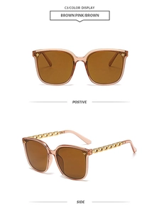 Detail of square oversized brown pink sunglasses with golden chain temples and brown lenses