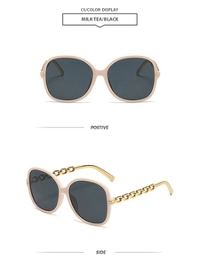 Détail de lunettes de soleil thé au lait avec branches en chaîne dorée et verres foncés