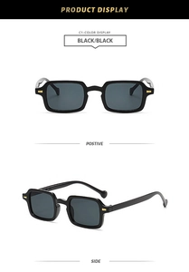 Detail view of black square frame sunglasses with golden metal accents on temples