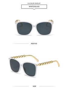 Detail of white square sunglasses with signature gold metal chain temples and dark lenses