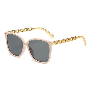 Chic square oversized sunglasses with pink frames and gold chain link temples on white background