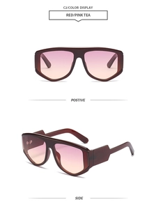 Dettaglio degli occhiali da sole oversize con lenti sfumate rosso e tè rosa e montatura spessa