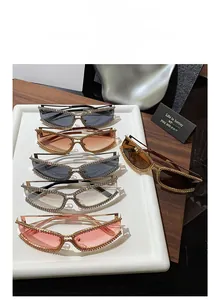 Close-up of rhinestone-studded cat-eye sunglasses in various colors on a tray