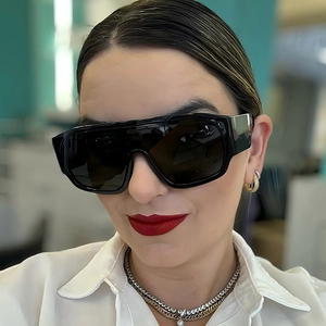 Gros plan de lunettes de soleil masque noires oversize élégantes avec logo doré