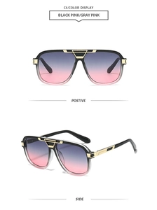 Detail view of square sun glasses with gold metal accents and black to pink gradient lenses