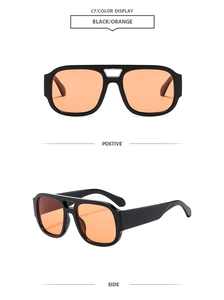 Close-up of retro double-bridge sunglasses with black frames and orange lenses