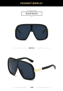 Detail view of black shield sunglasses with luxury gold metal hinges and dark lenses