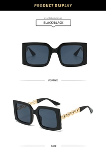 Detail of square sunglasses with golden metal chain temples and black frame