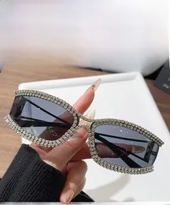 Detail of crystal-encrusted gunmetal rectangular sunglasses with dark grey lenses