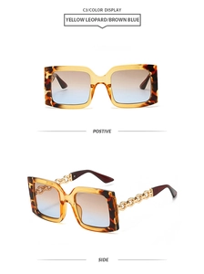 Detail of yellow leopard sunglasses featuring unique gold metal chain temples and gradient lenses