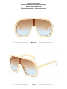 Detail view of beige oversized shield sunglasses with brown-blue gradient lenses and metal hinges