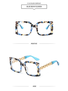 Detail view of square sunglasses featuring blue floral patterns and gold chain temples