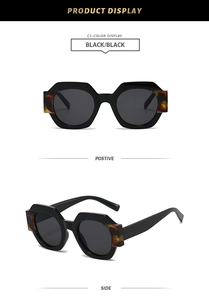 Detail view of stylish hexagonal sunglasses with black frames and tortoiseshell accents