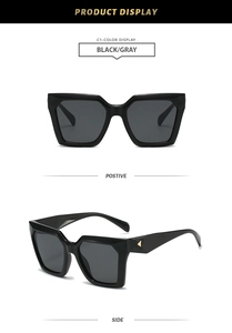 Detail view of black square oversized sunglasses with gold triangular metal temple accent