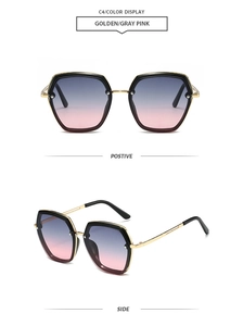Detail view of vintage hexagonal sunglasses with gold frames and grey pink gradient lenses