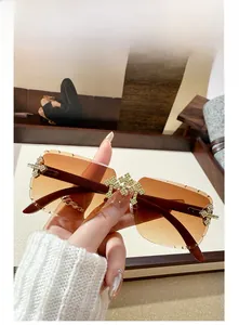 Detail of rimless square sunglasses with brown gradient lenses and crystal cross accents