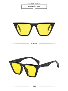 Detail of retro black polygon sunglasses with yellow lenses and silver rivets on the frame