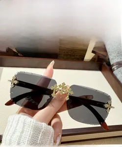 Detail of grey rimless sunglasses featuring golden rhinestone crosses and wood grain temples