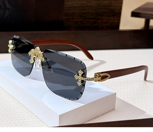 Close-up of rimless grey sunglasses with wood-grain temples and gold diamond-encrusted C-hinge