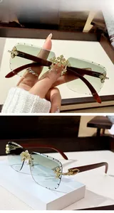 Close-up of rimless square sunglasses with gradient green lenses and gold cross detail