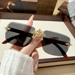 Fashion rimless square sunglasses featuring crystal cross decor and jagged edge lenses