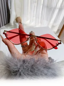 Detailed macro view of diamond-encrusted rimless ruby red diamond-shaped sunglasses