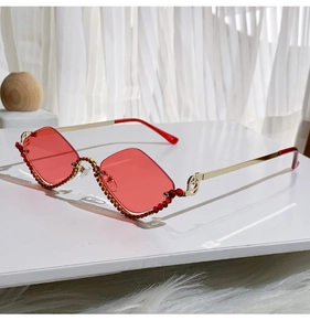 Detail of red rhinestone trim on diamond shaped semi-rimless vintage metal sunglasses