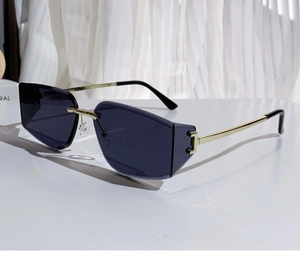 Close-up of frameless geometric sunglasses with dark lenses and gold metal temples
