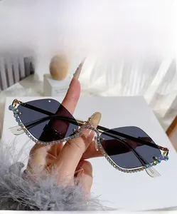 Detail of grey diamond-rimmed sunglasses with colorful rhinestones and gold metal frame