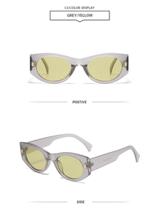 Macro shot of grey cat-eye sunglasses with yellow lenses and gold metal temple details