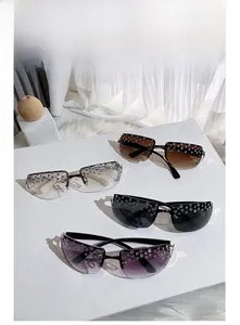 Detailed view of luxury rimless sunglasses with rhinestone accents in multiple color lens