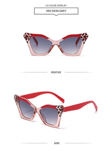 Detail view of red butterfly sunglasses with leopard print accents and grey gradient lenses