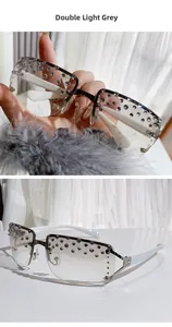 Close-up of double light grey rimless sunglasses with rhinestone accents and white temples