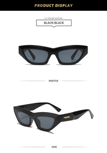Detail of black geometric cat-eye sunglasses with gold accents and dark grey lenses