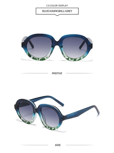 Detail of oversized retro sunglasses with blue-grey gradient frame and tortoiseshell pattern