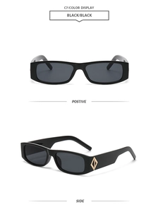 Détail de lunettes de soleil rectangulaires noires avec ornements géométriques dorés