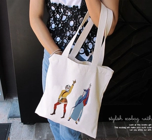 Detail of white canvas tote bag with Sun Wukong character print on model shoulder