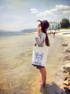 Detail of white canvas tote bag with red and blue lettering print for casual outdoor use