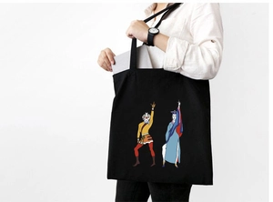Detail of black canvas tote bag showing Sun Wukong print and a laptop inside