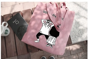 Dettaglio di una borsa tote in tela rosa con stampa artistica su una panca in legno