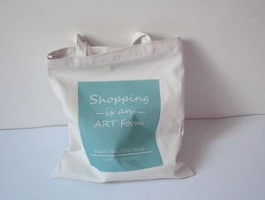 Detail of canvas tote bag with Shopping is an ART Form print on blue block design