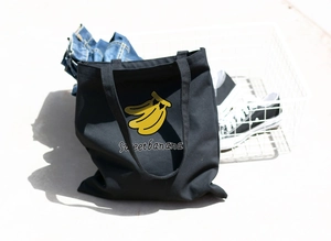 Black canvas tote bag with yellow banana print and Sweet banana text for daily casual use