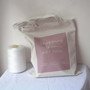 Close-up of artistic lettering on a cream canvas tote bag for a lifestyle aesthetic