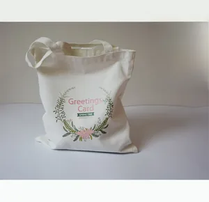 Détail du sac cabas en toile blanc cassé avec couronne de fleurs et motif imprimé