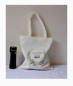 Détail d'un sac cabas en toile blanche avec motif couronne de fleurs roses