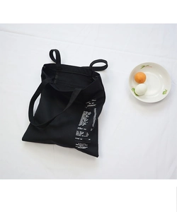 Black canvas tote bag with creative white supermarket receipt print detail on white fabric