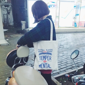 Street view of a white canvas tote bag with funny football players typography