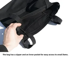 Detail view of black canvas tote bag featuring zipper closure and interior security pocket